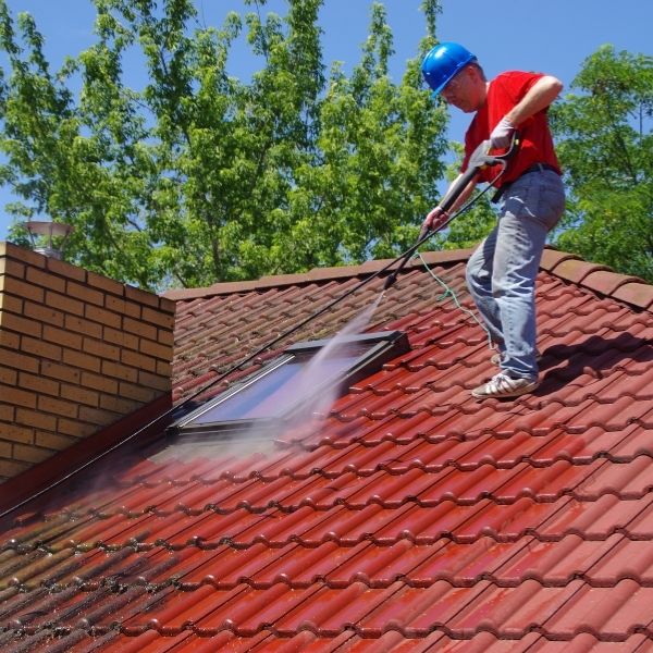 Roofing Guys Perth crew completing roof cleaning using high-pressure washing to clear debris and brighten a tiled roof surface.