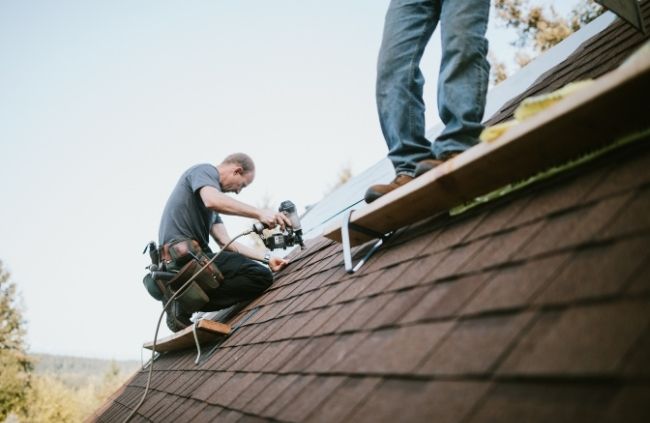 Skilled tradesmen from Roofing Guys Perth completing roof restoration work on a steep roof with proper safety gear.